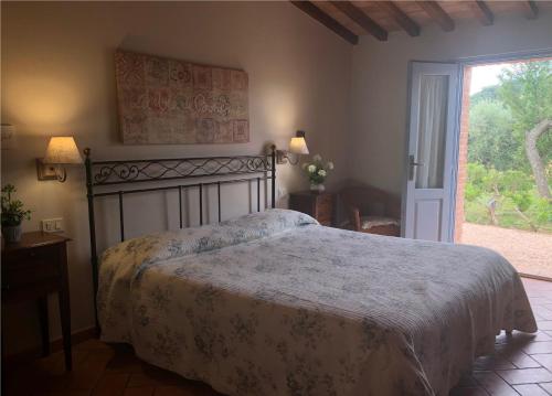 a bedroom with a bed and a large window at Bio Agriturismo Le Cascatelle in Saturnia