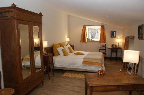 a bedroom with a bed and a dresser and a mirror at Les FREJALS in Compeyre