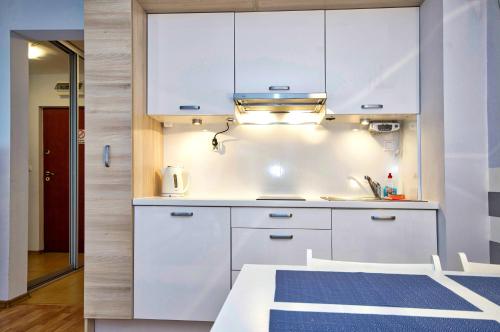eine Küche mit weißen Schränken und einem blauen Teppich in der Unterkunft Apartament Park Zdrojowy 2 in Świnoujście