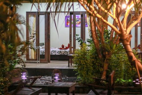 a room with plants and a bed in the background at Medori Putih Homestay in Uluwatu