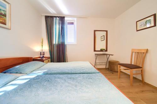 1 dormitorio con 1 cama, 1 mesa y 1 silla en Apartman ANTICA, en Vantačići