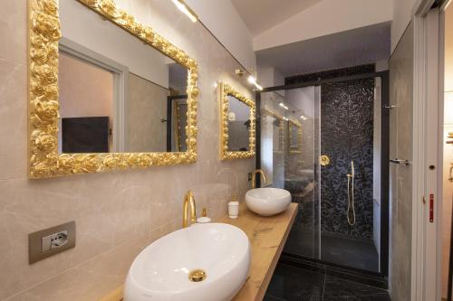 a bathroom with two sinks and a shower with mirrors at La Togata Hotellerie de Charme Relais il Terrazzo in Montalcino