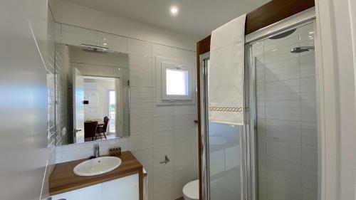 a bathroom with a sink and a toilet and a mirror at Hotel Selwo Lodge - Animal Park Tickets Included in Estepona