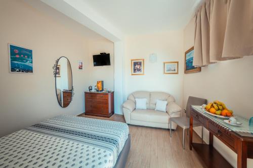 a bedroom with a bed and a couch and a table at Elegant R&B Floridia in Taormina