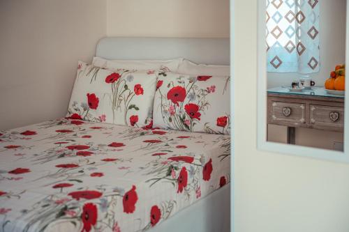 a bedroom with a bed with red flowers on it at Elegant R&B Floridia in Taormina