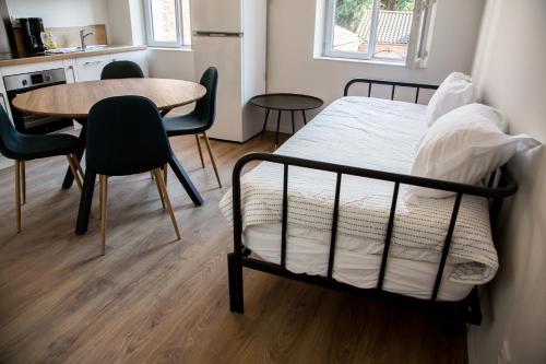 ein Schlafzimmer mit einem Bett und einem Tisch und Stühlen in der Unterkunft ALBIAPPART VIGAN centre ville in Albi