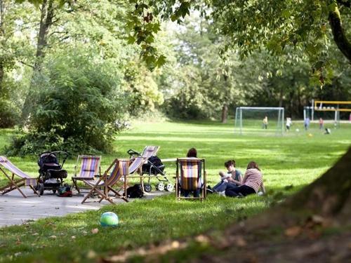 Un groupe de personnes assises sur l'herbe dans un parc dans l'établissement Haus Müllestumpe, à Bonn