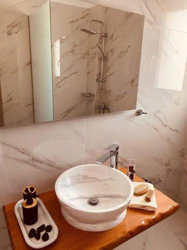 a bathroom with a white sink and a mirror at Anemoss Saranti in Paralia Saranti