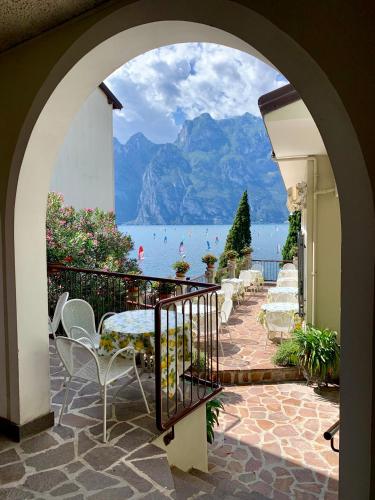 an archway leading to a patio with a view of the water at Casa Romani Lake Apartments in Nago-Torbole
