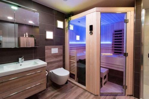 a bathroom with a toilet and a sink and a shower at 5 Sterne Penthouse DeichSuite in Büsum