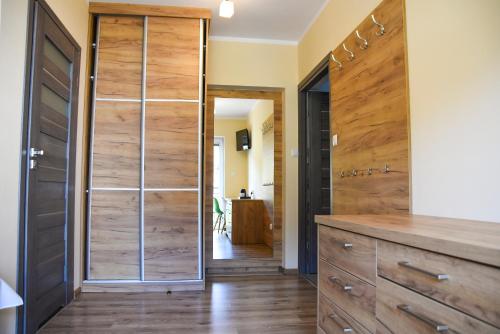 a pivot door in a kitchen with wood paneling at Willa Szczepaniakówka in Szczawnica