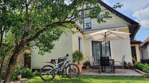 una bicicleta estacionada frente a una casa con un paraguas en Chalupa U Miška, en Hyby