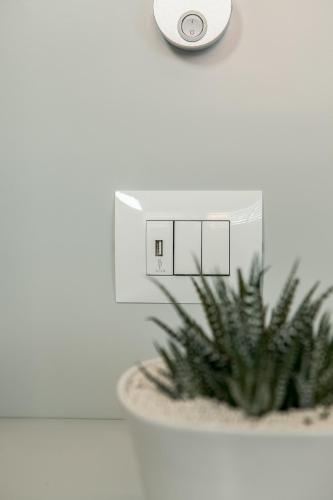 a lightswitch on a wall next to a plant at ODA Aparthotel Shkodër in Shkodër