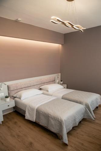 a bedroom with two beds and a chandelier at ODA Aparthotel Shkodër in Shkodër