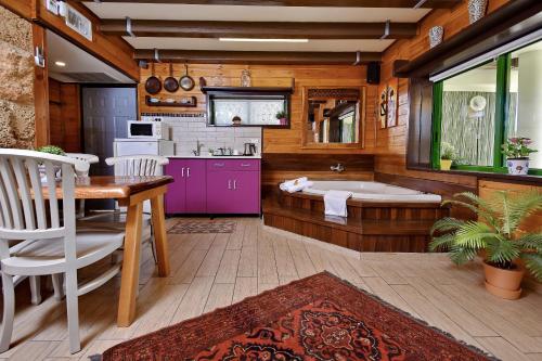 a bathroom with a tub and a table and chairs at Out of Africa Resort in Had Nes