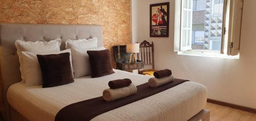 um quarto com uma cama grande com almofadas e uma janela em Casa do Criativo ® Bed&Breakfast em Almada