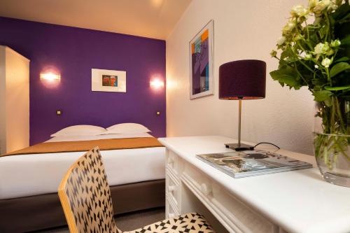 a bedroom with a bed with a purple wall at Le Hameau de Passy in Paris