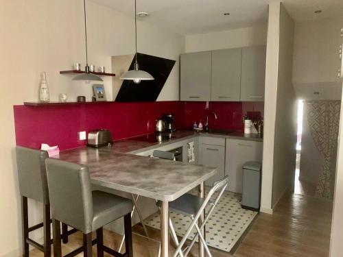 Una cocina con una mesa y sillas en una habitación. en Appartement Versailles quartier Notre Dame au pied du Chateau avec Parking, en Versalles