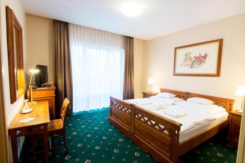 a hotel room with a bed and a desk at Orchidea Hotel Lip&oacute;t in Lip&oacute;t