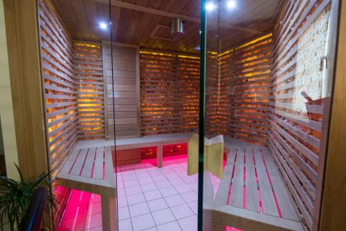 eine Sauna mit Bänken in einem Zimmer mit Beleuchtung in der Unterkunft Orchidea Hotel Lipót in Lipót
