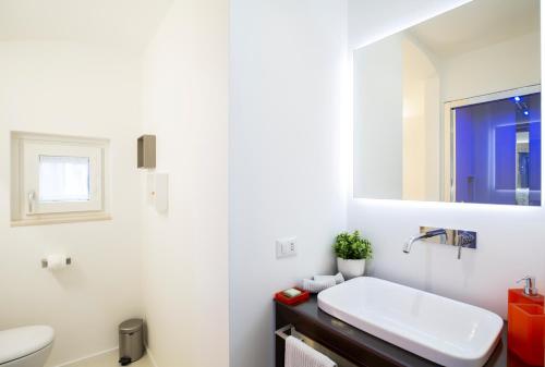 a bathroom with a sink and a toilet and a mirror at Al Castello Relais in Vieste