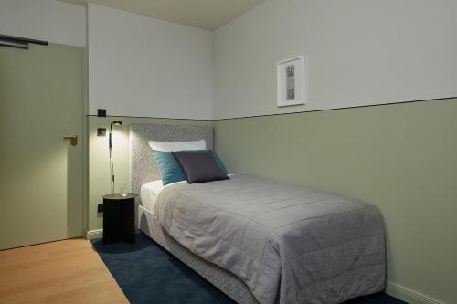 a bedroom with a large bed with a blue rug at stilwerk Hotel Heimhude in Hamburg