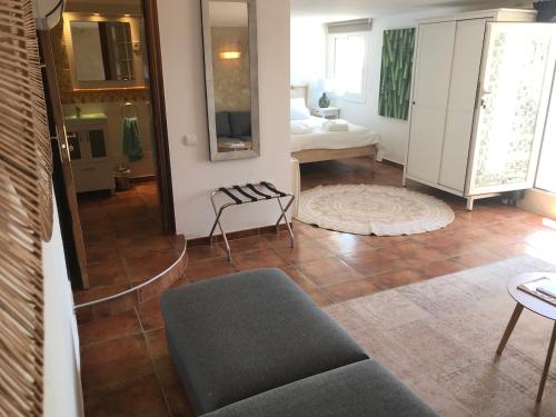 a living room with a couch and a bedroom at Casa Mallarenga Rooms in Olivella