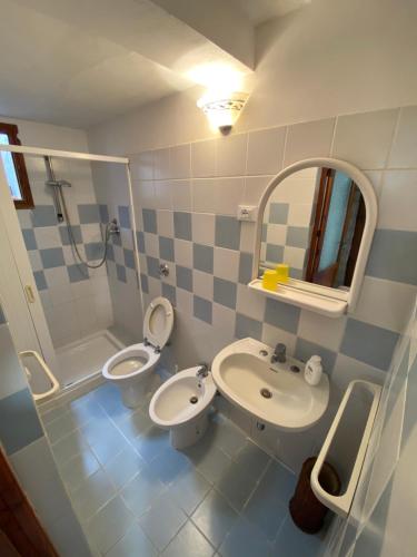 ein Badezimmer mit einem Waschbecken, einem WC und einem Spiegel in der Unterkunft Il rifugio del viaggiatore in Favignana