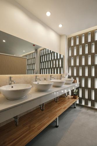 a row of four sinks in a public bathroom at Hidden Garden Hostel in Chiang Mai