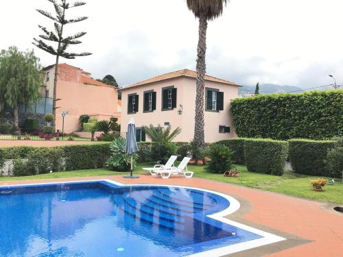 a villa with a swimming pool and a house at Casa Charmosa in Funchal