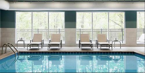 a hotel swimming pool with chairs and a table at Holiday Inn Express & Suites - Goodland I-70, an IHG Hotel in Goodland