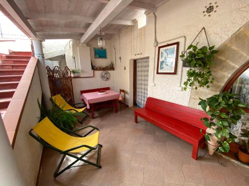 um banco vermelho numa sala com cadeiras e uma mesa em Il rifugio del viaggiatore em Favignana