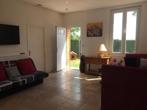 ein Wohnzimmer mit einem Sofa und einem TV in der Unterkunft LA BELLE ETOILE in Auneau