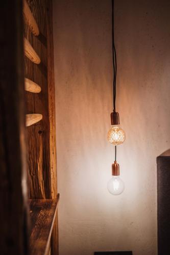 two lights hanging in a room with a wall at Gästehaus Richter in Grainau