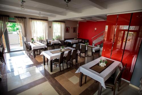 a restaurant with tables and chairs and red walls at Restauracja Sonata in Zwierzyniec