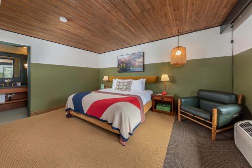 um quarto com uma cama e uma cadeira em Station House Inn South Lake Tahoe, by Oliver em South Lake Tahoe