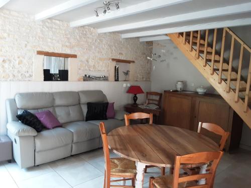 a living room with a couch and a table at Gîte " Les Tourterelles" in Thaims