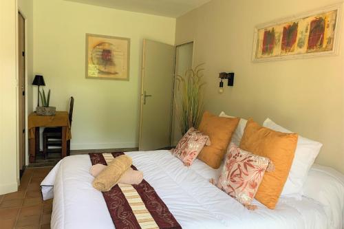 1 dormitorio con cama blanca y almohadas en La Villa Saint André - Argeles sur mer, en Argelès-sur-Mer