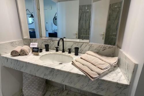 un comptoir de salle de bain avec un lavabo et un miroir dans l'établissement GALETS BLEUS by K6 Conciergerie Prestige, à Cassis