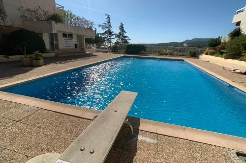 - une piscine avec banc devant un bâtiment dans l'établissement GALETS BLEUS by K6 Conciergerie Prestige, à Cassis