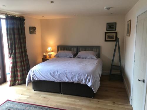 a bedroom with a bed with white sheets and pillows at Kilmorie House in Elgin
