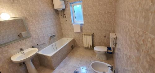 une salle de bain avec une baignoire, un lavabo et des toilettes dans l'établissement Apartment Nautica Topla, à Herceg-Novi