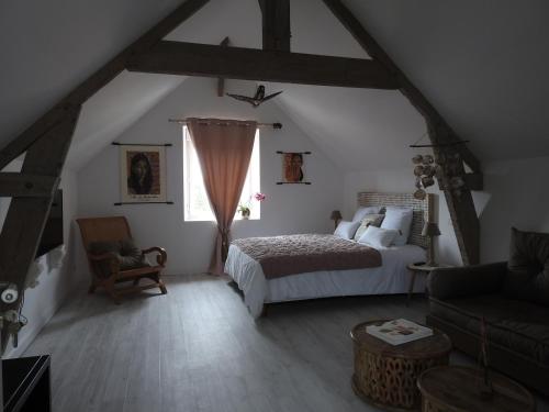 une chambre avec un lit et une chaise dans un grenier dans l'établissement Villa Madura, à Saint-Michel-Chef-Chef