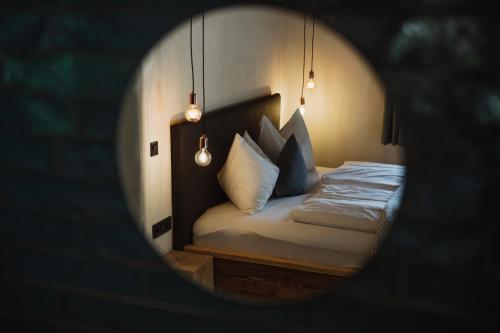 a small bedroom with a bed with white pillows at Gästehaus Richter in Grainau