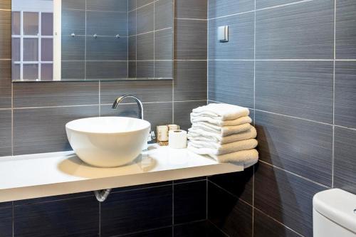 bagno con lavandino, specchio e asciugamani di Apartamentos Carteia a Quarteira