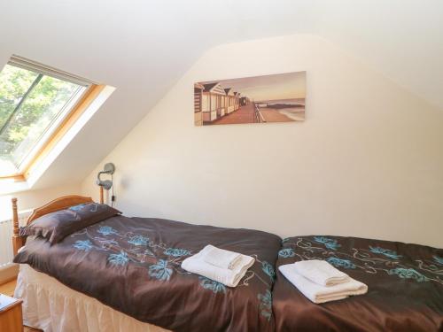 a bedroom with a bed and a picture on the wall at Garth Morthin The Stables in Morfa Bychan
