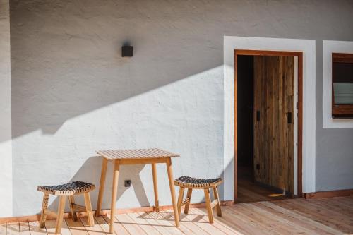 a table and two stools sitting next to a door at Gästehaus Richter in Grainau