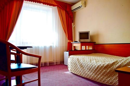 a bedroom with a bed and a television and a window at Hotel Complex Vizit in Kozin