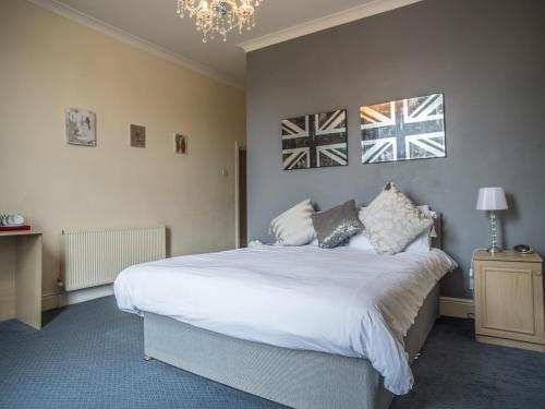 a bedroom with a large white bed and a chandelier at Baytrees Hotel in Southport