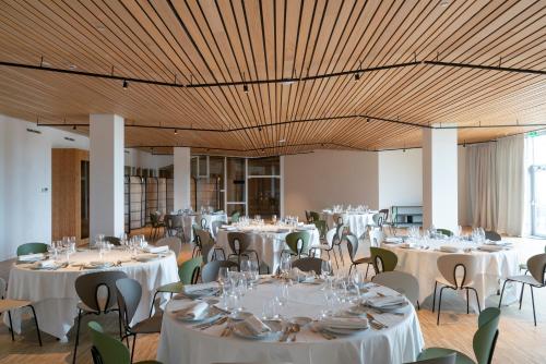a banquet hall with white tables and chairs at Parador Costa da Morte in Muxia